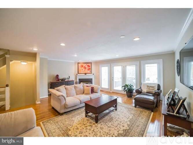 A living room with a couch, a chair, a coffee table, and a fireplace.