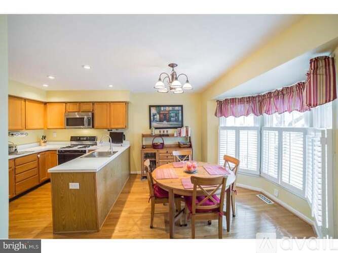 A kitchen with wooden cabinets and a dining table with chairs.