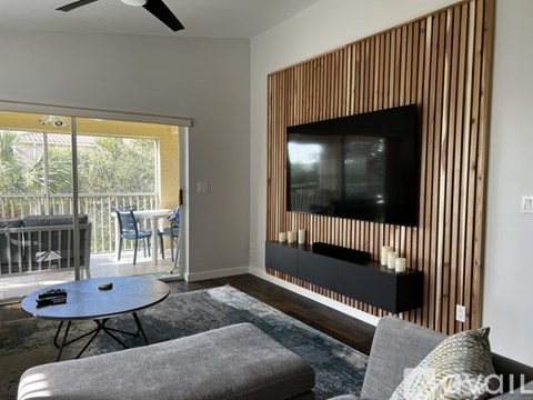 A living room with a television and sliding glass doors.
