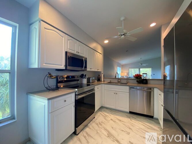 A kitchen with white cabinets and a black stove top oven.