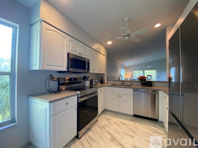 A kitchen with white cabinets and a black stove top oven.