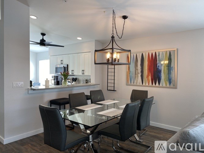 A modern dining room with a glass table and chairs.