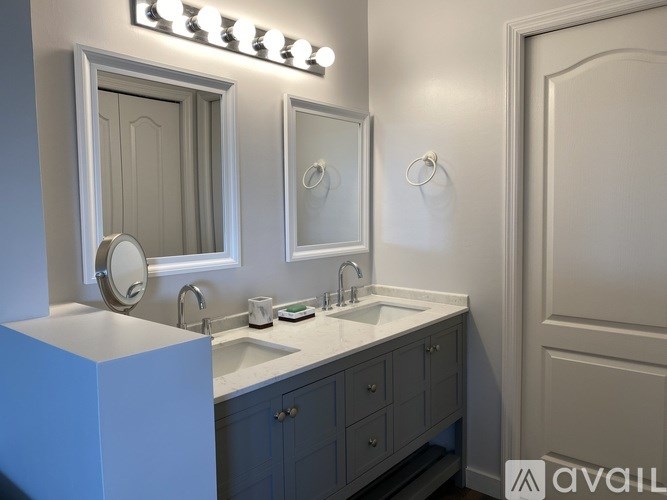 A bathroom with a white sink and a mirror above it.