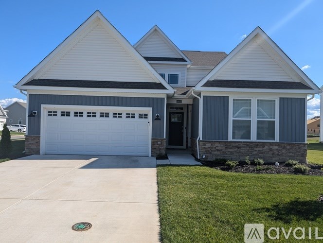 A two-story house with a garage is available for sale.
