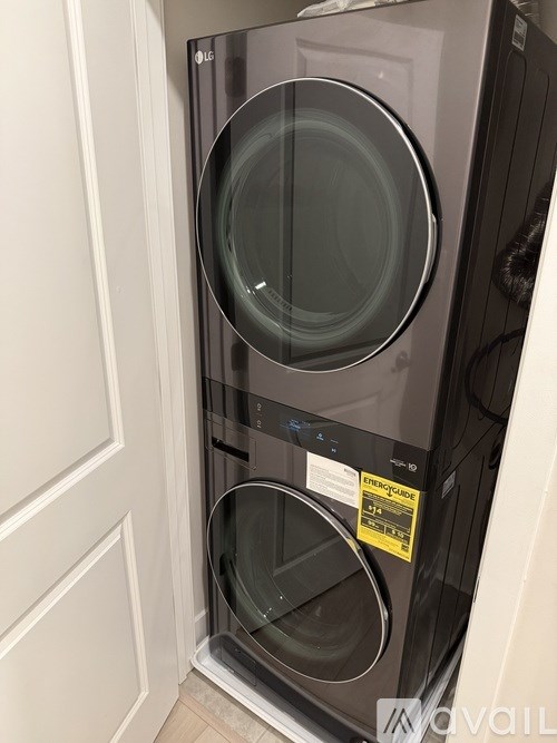 A black LG front loading washing machine with a yellow caution label on the door.