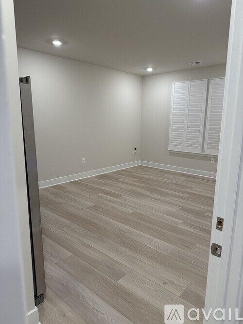 A room with light wood flooring and white walls.