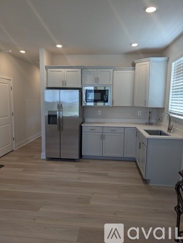 A kitchen with a refrigerator, microwave, and cabinets.