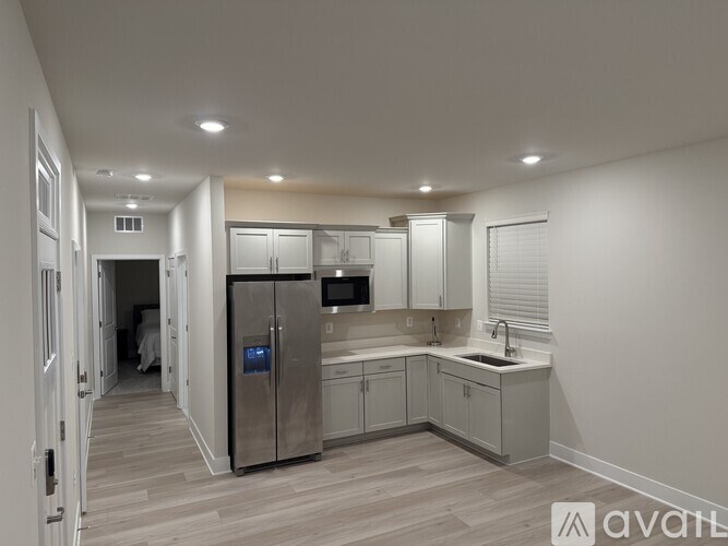 A modern kitchen with a refrigerator, microwave, and sink.