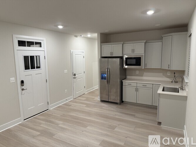 A kitchen with white cabinets and a refrigerator.