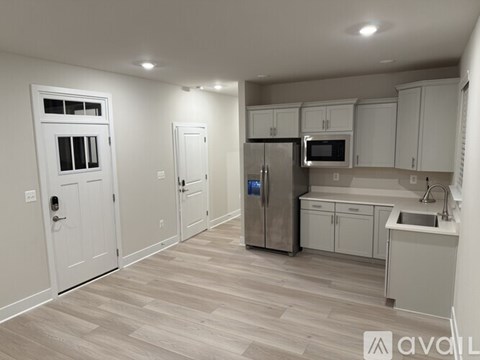 A kitchen with white cabinets and a refrigerator.