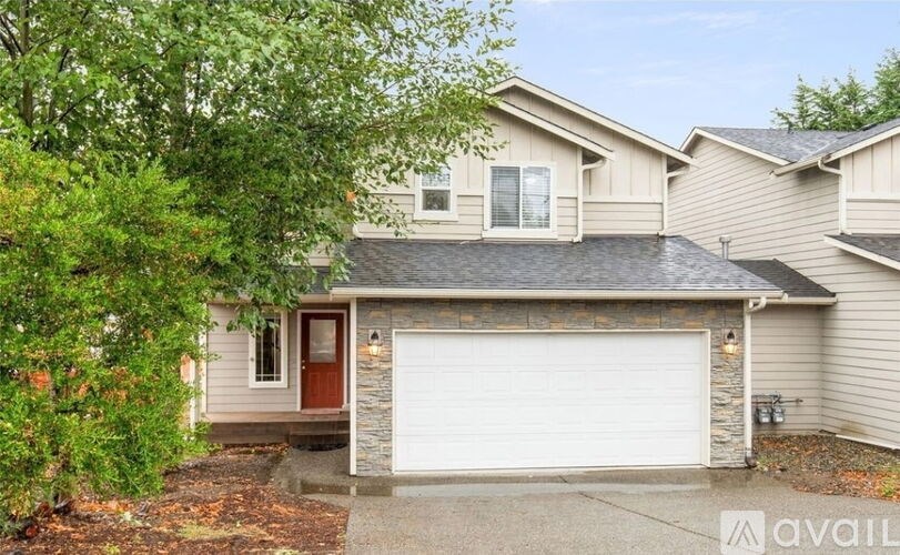 A house with a brown door and a white garage door.