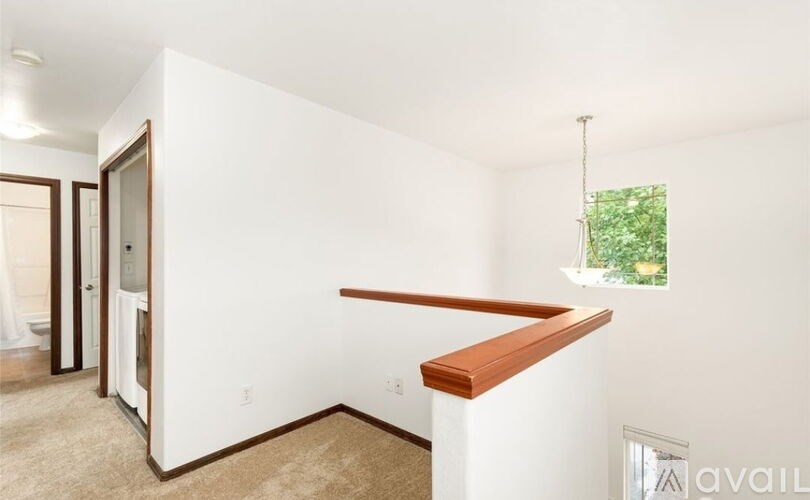 A room with a window and a wooden ledge on the wall.