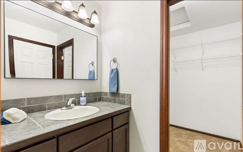 A bathroom with a sink, mirror, and towel.