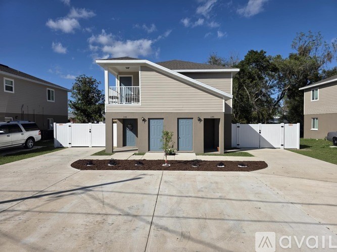A house with a garage and a driveway in front of it.