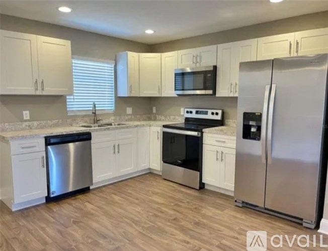 A kitchen with white cabinets and stainless steel appliances.