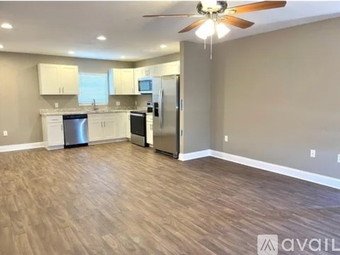 A kitchen with a refrigerator, microwave, and oven.