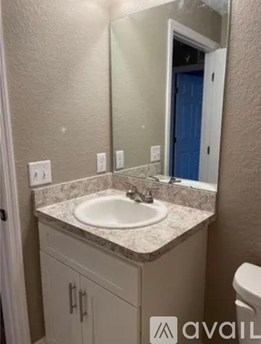 A bathroom with a sink, mirror, and toilet.