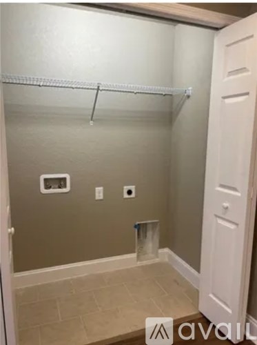 A small, empty room with a white door and a white shelf.
