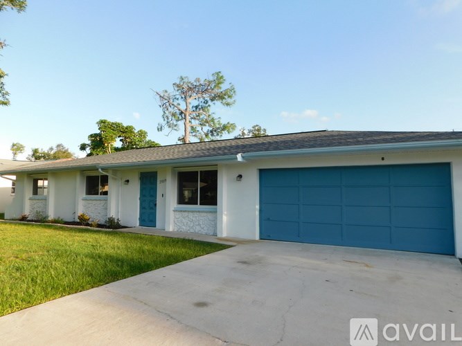 A house with a blue garage door is for sale.