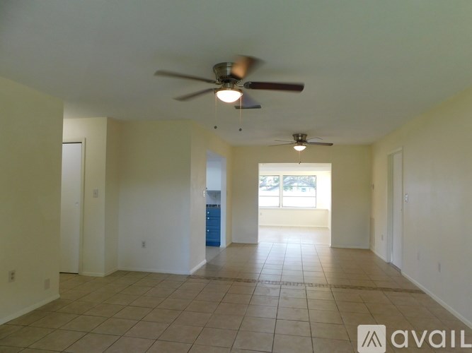 A spacious room with a ceiling fan and tiled floor.
