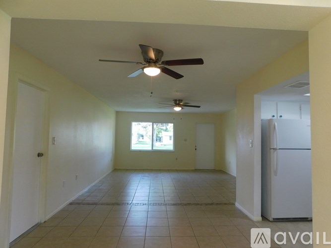 A room with a ceiling fan and tile flooring.