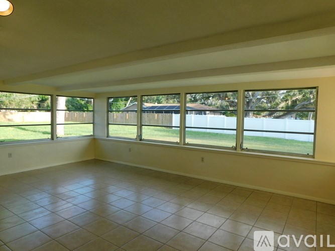 Empty room with large windows and tiled floor.