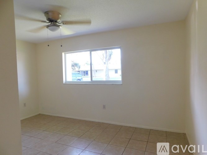 A room with a ceiling fan and a window.