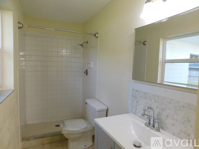 A bathroom with a toilet, sink, and shower.