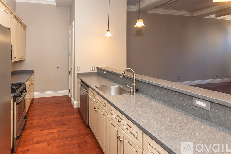 A kitchen with wooden floors and a grey countertop.