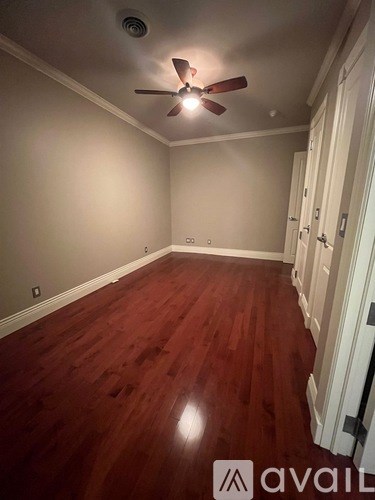 A room with wooden floors and a ceiling fan.