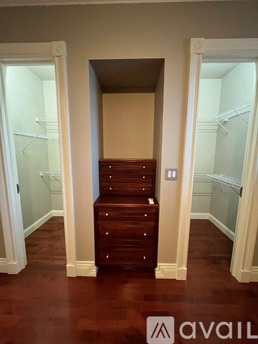 A hallway with a staircase and a white door.