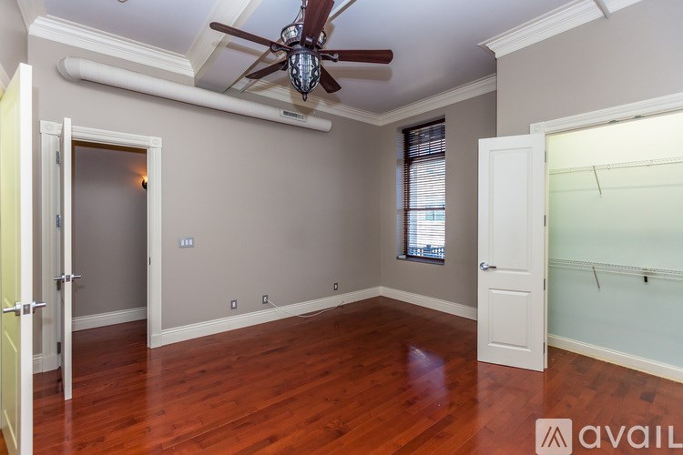 A room with a ceiling fan and wooden floors.