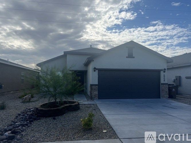 A house with a garage and a gravel area in front.