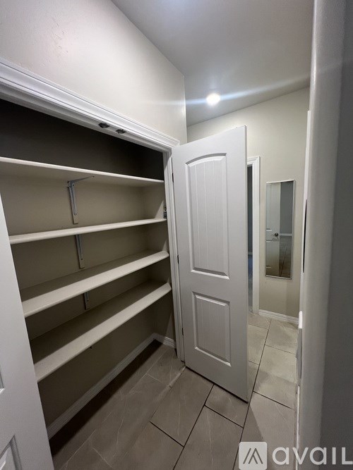 A white closet with shelves and a door.