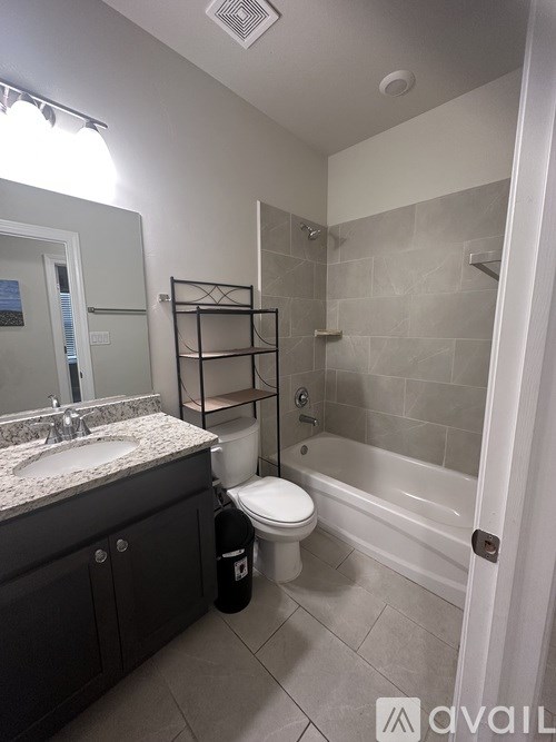 A bathroom with a toilet, sink, and bathtub.