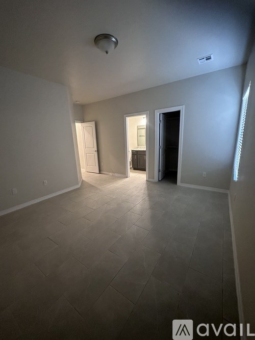 A room with a tiled floor and a doorway leading to another room.
