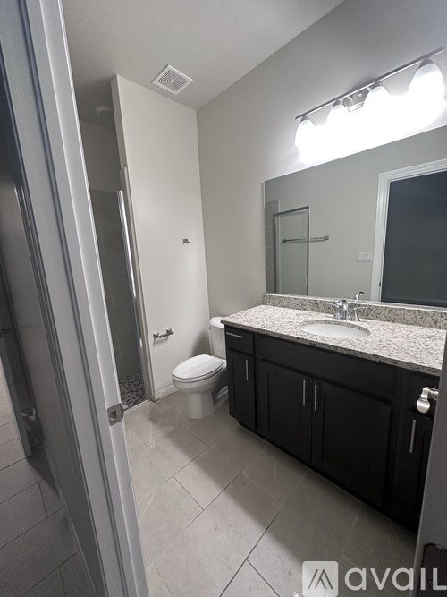 A bathroom with a toilet, sink, and mirror.