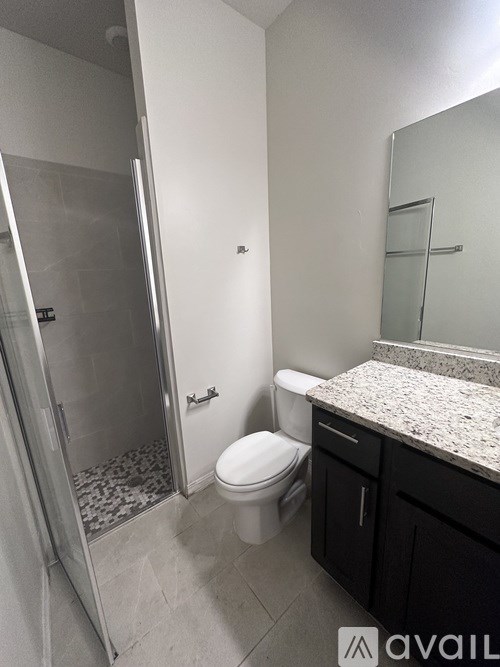 A bathroom with a toilet, sink, and walk-in shower.