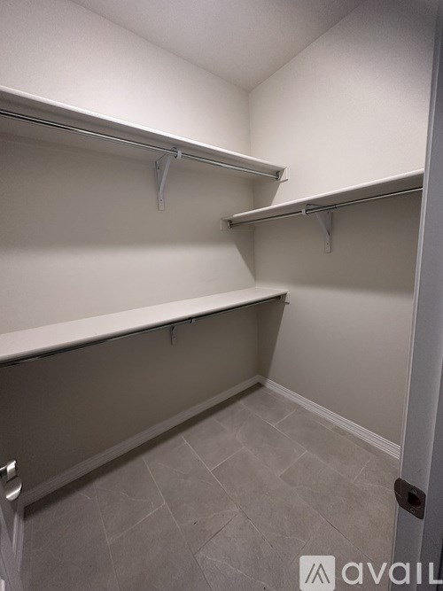 A white closet with shelves and hooks.