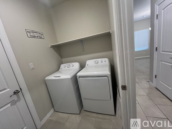 A laundry room with two washing machines and a sign on the wall.