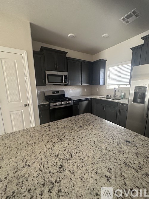 A kitchen with granite countertops and stainless steel appliances.