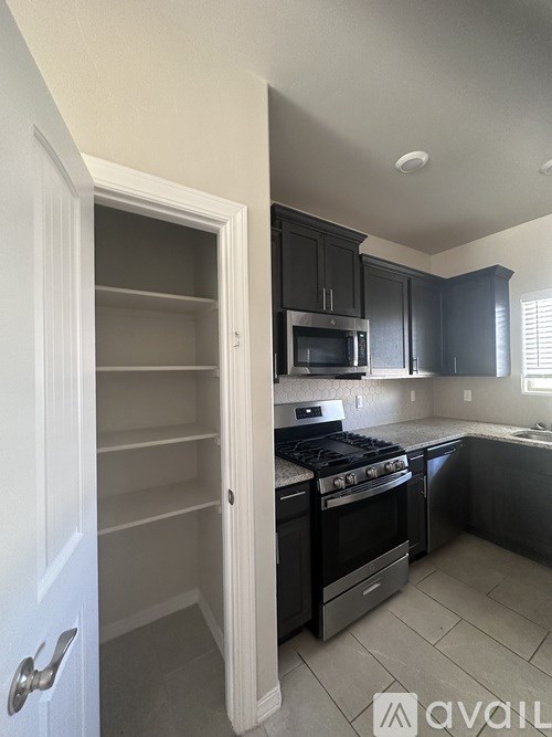 A kitchen with black cabinets and a stove top oven.