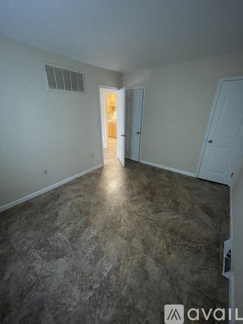 A room with a tiled floor and a doorway leading to another room.