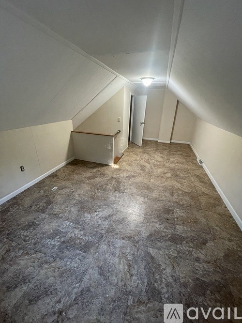 A room with a carpeted floor and a door at the end.