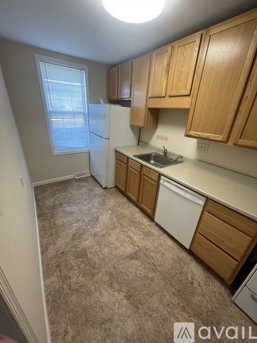 A kitchen with wooden cabinets and a white fridge.