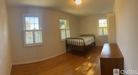 A bedroom with a bed, dresser, and window.