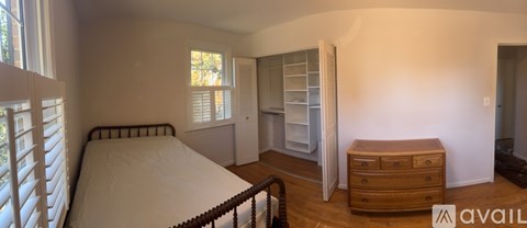 A bedroom with a bed, dresser, and wardrobe.