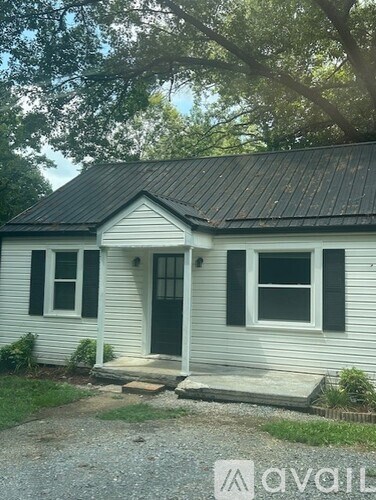 A small white house with a black door and windows.
