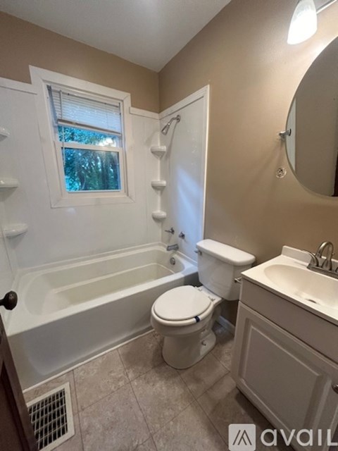 A bathroom with a white tub, toilet, and sink.