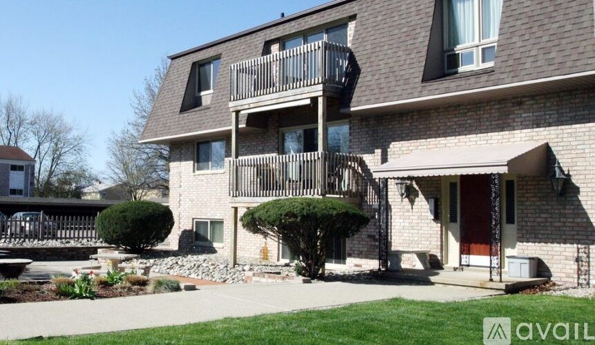 A house with a balcony and a red door.